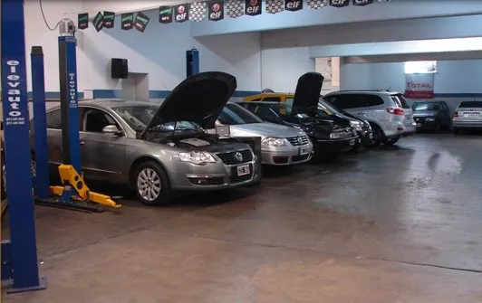 Autos con el capó abierto en el área de servicio