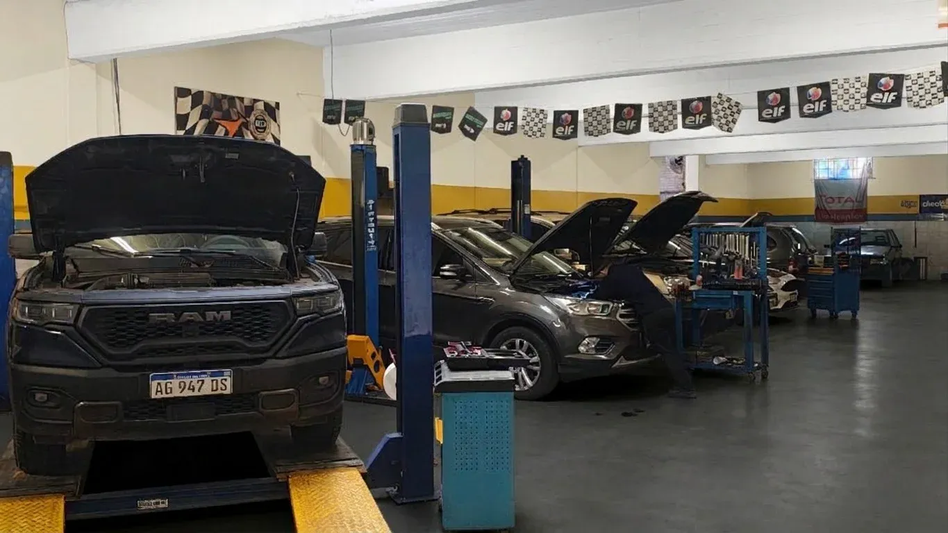 Interior del taller Montero Hnos., con autos en los elevadores